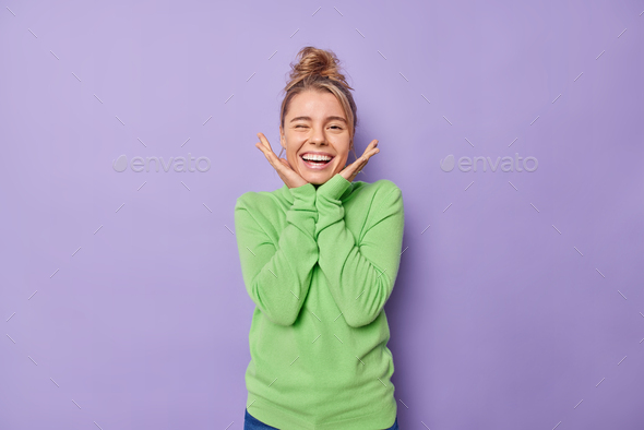 Positive Young Blonde European Woman Winks Eye And Smiles Broadly Keeps Hands Under Chin Feels 9620